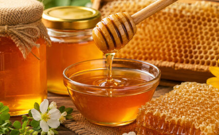 Natural honey being sampled from a food grade bulk container